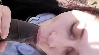 Sucking black cock outside in park